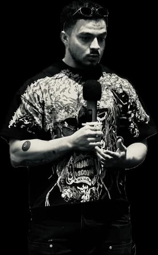 Adrián speaking on stage, holding a microphone.